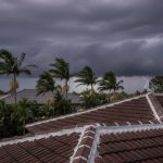Modern Brisbane home with a solid, freshly repointed tiled roof standing strong against approaching dark storm clouds, symbolizing storm season readiness.